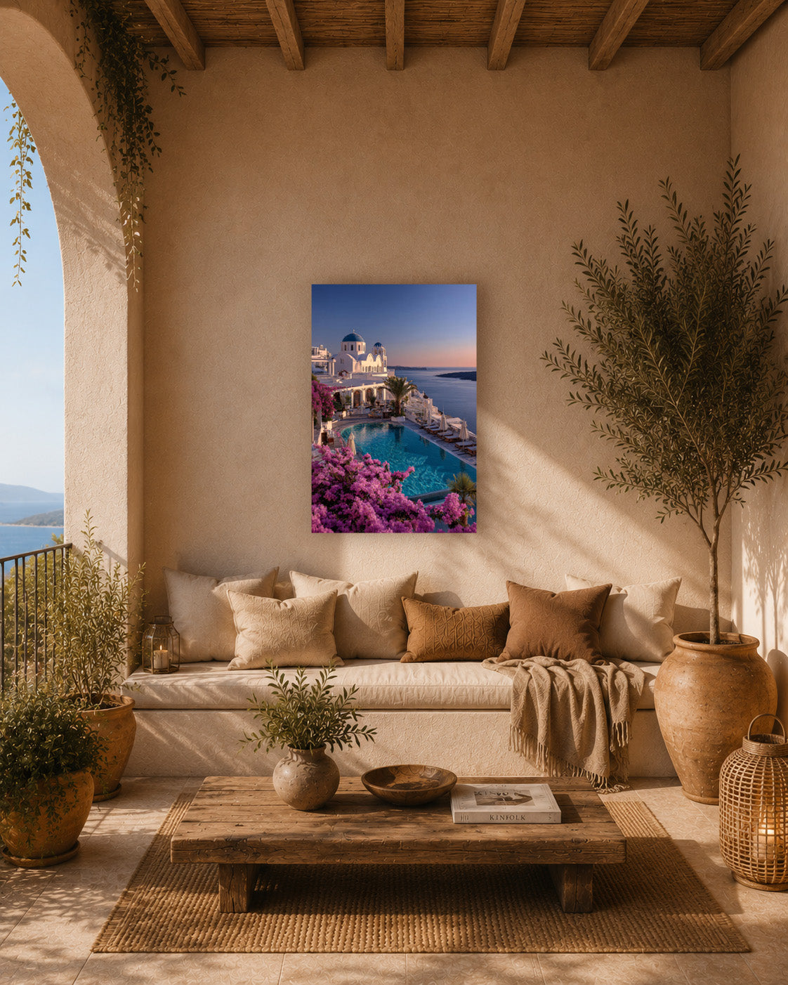Santorini poster print on a terrace wall beside a low sofa, potted plants and a sea view