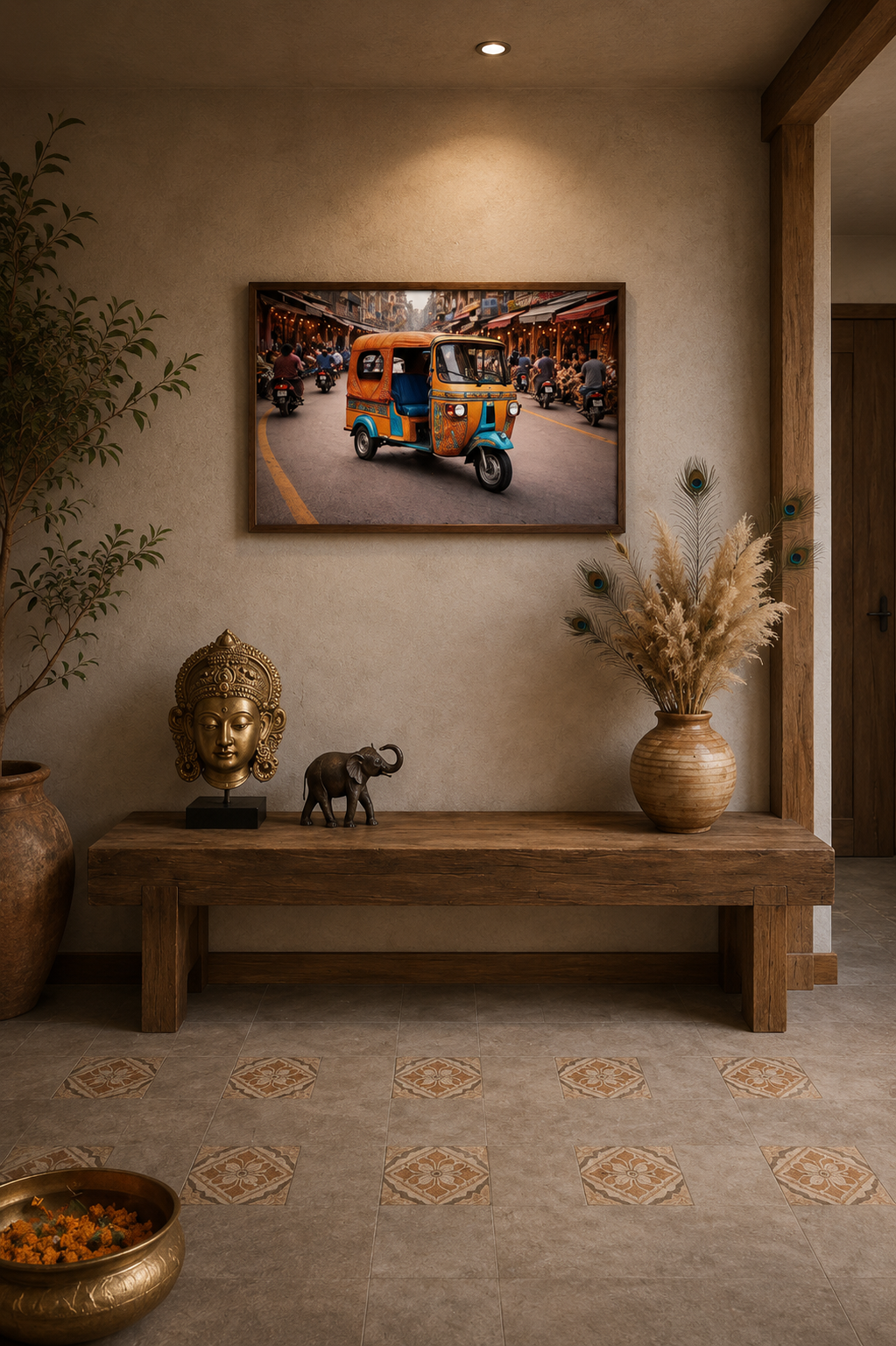 Framed tuk tuk street print above wooden bench in minimalist entryway with brass statue, elephant decor and dried pampas arrangement.