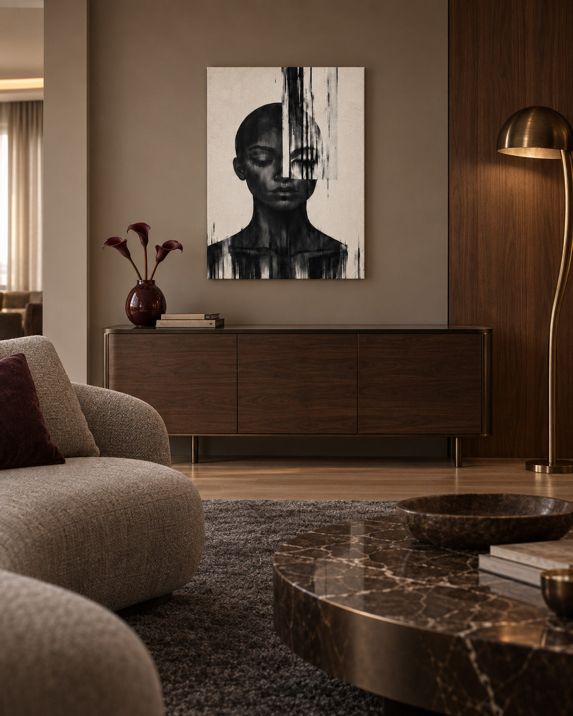 Black and white abstract woman portrait canvas above a wooden sideboard in a modern living room with a marble coffee table and brass floor lamp.