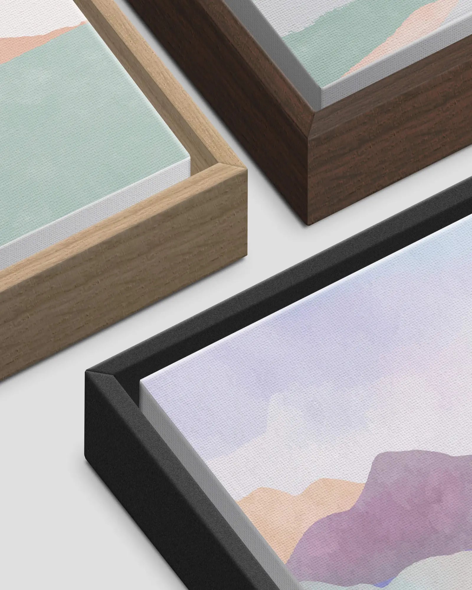 Close-up of light wood, dark wood and black floating frame finish options for canvas artwork