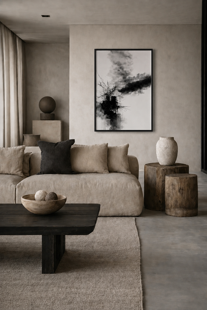 Black and white abstract wall art with a realistic black wooden frame displayed in a warm minimalist living room with beige sofa and natural wood accents.