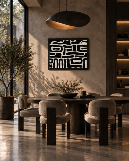 Graphic black and white wall art displayed in a warm modern dining room