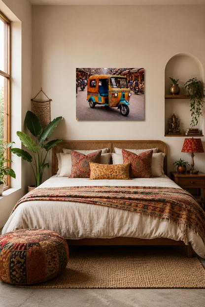Colorful Indian tuk tuk wall art displayed above a bed in a warm modern bedroom with neutral decor and earthy accents.