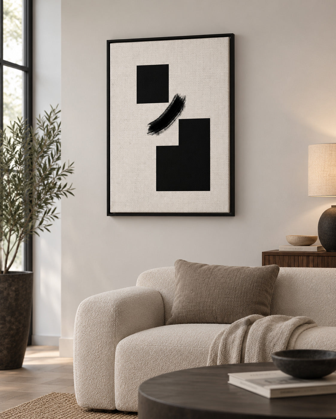 Minimal geometric black and white artwork displayed in a modern neutral living room