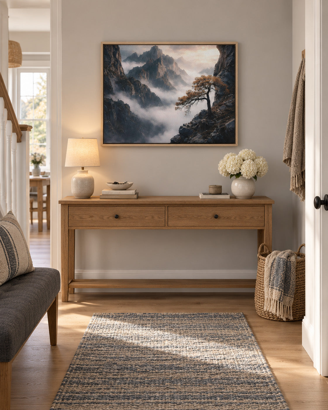 Misty mountain landscape artwork displayed above a console in a modern entryway