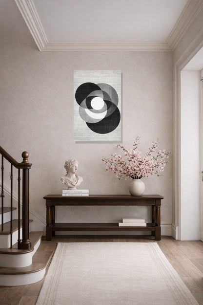 The abstract poster in a bright hallway above a dark wood console table beside a staircase
