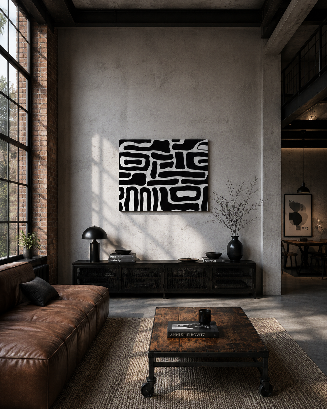 Black and white abstract canvas wall art in an industrial loft living room with leather furniture and exposed materials