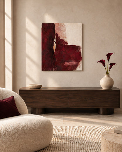 Oxblood Poise burgundy abstract canvas above a dark wood sideboard beside a cream lounge chair