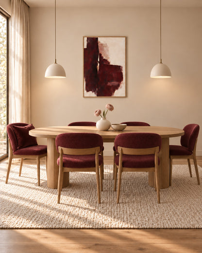 Oxblood Poise framed burgundy abstract poster above a wooden dining table with burgundy upholstered chairs