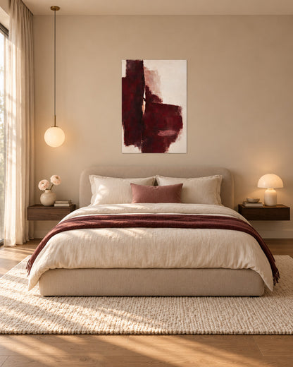 Oxblood Poise unframed burgundy abstract poster above a cream bed with a burgundy throw