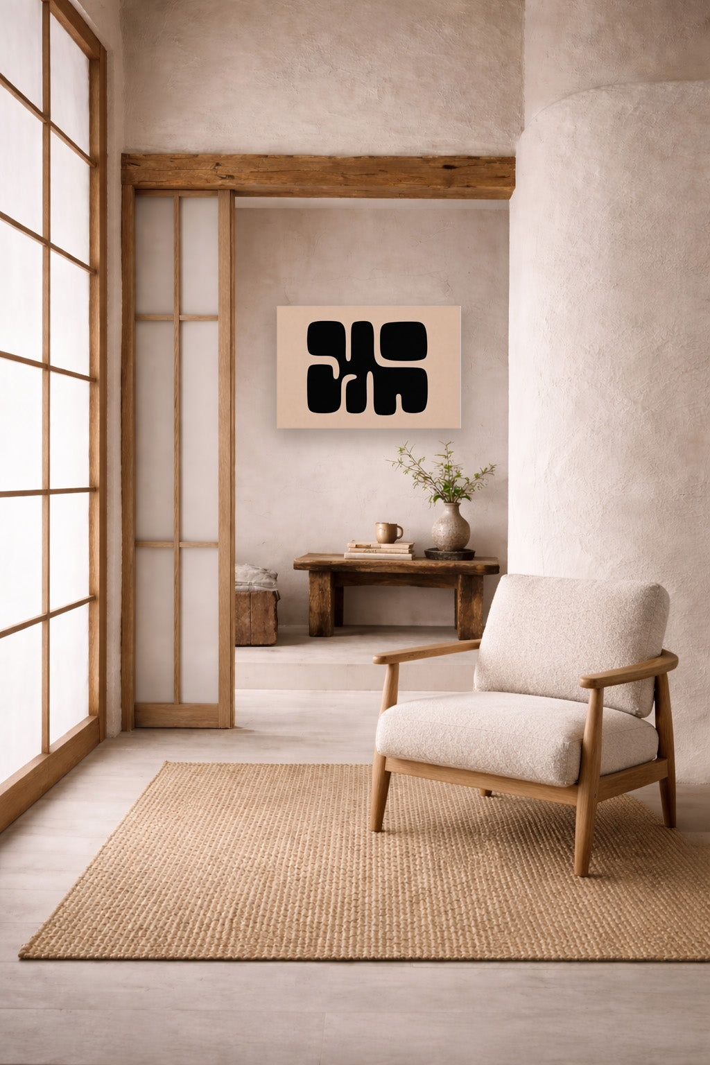 Abstract black canvas wall art in Japandi reading corner with wooden chair, neutral tones and minimalist styling.