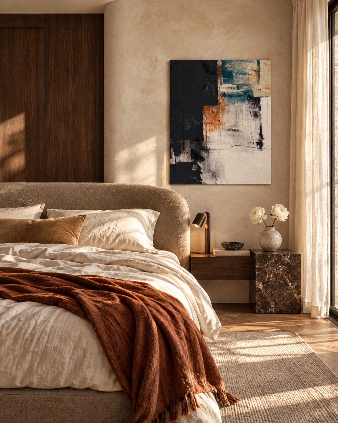 Teal and terracotta abstract canvas beside a bed with a rust throw in a warm neutral bedroom