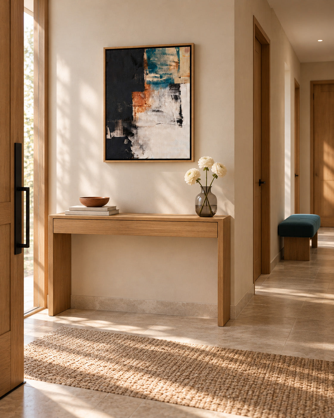 Oak framed abstract canvas above a floating console in a Japandi entryway
