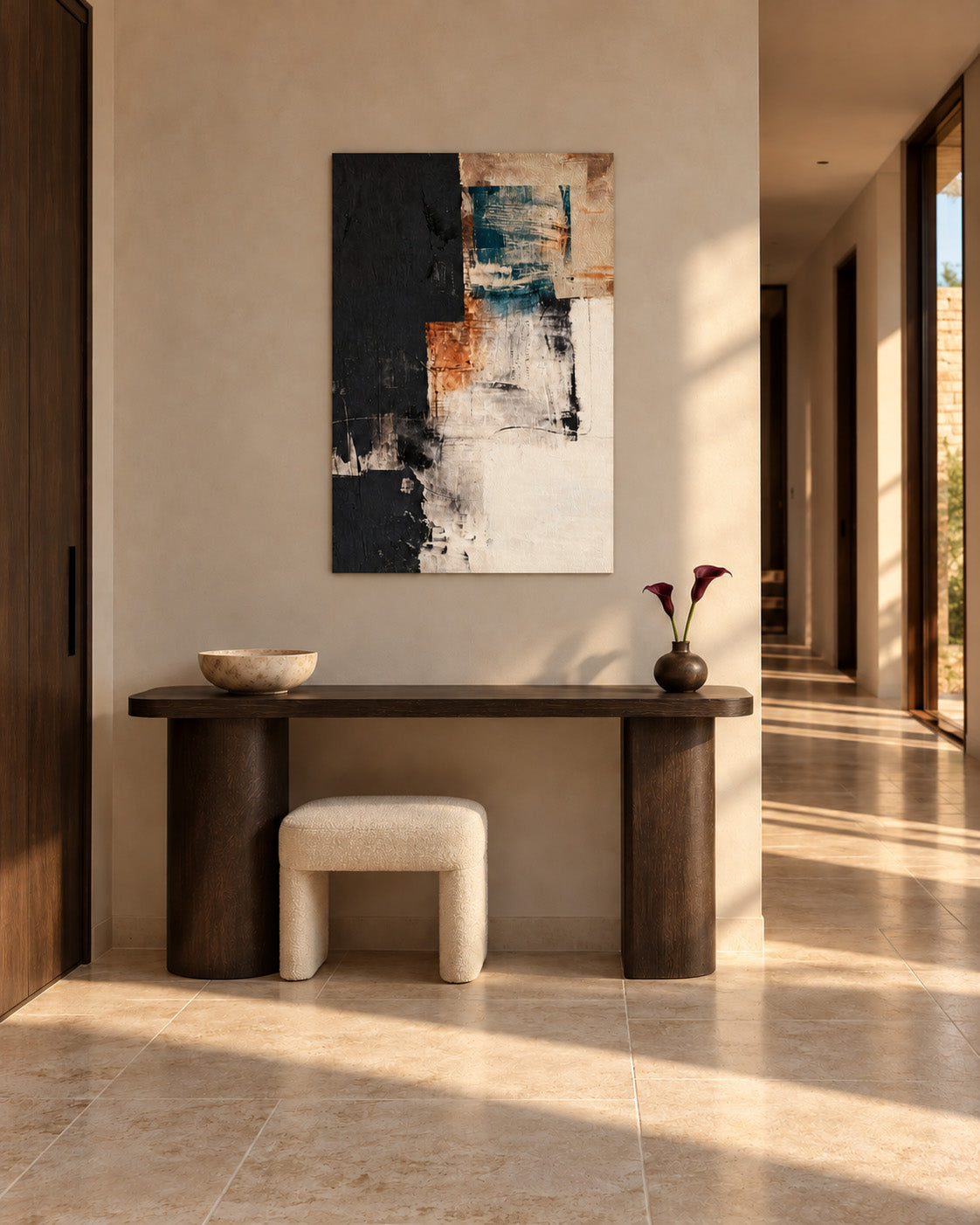 Abstract poster in teal, terracotta and black above a dark console and stool in a sunlit hallway