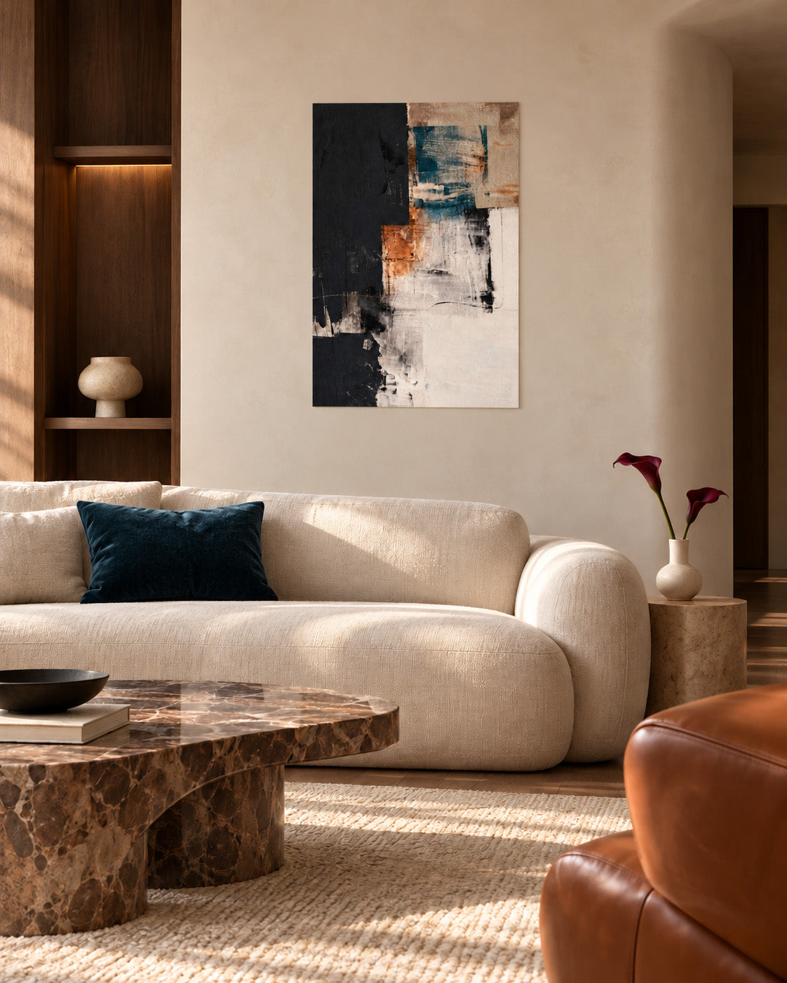 Teal and terracotta abstract poster above a curved cream sofa and marble coffee table in a sunlit living room